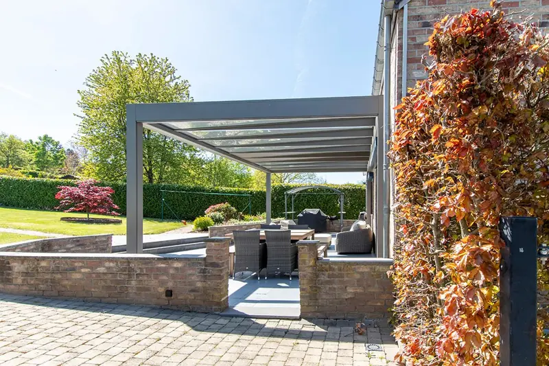 Pergola aluminium autoportante au-dessus d’une terrasse pavée