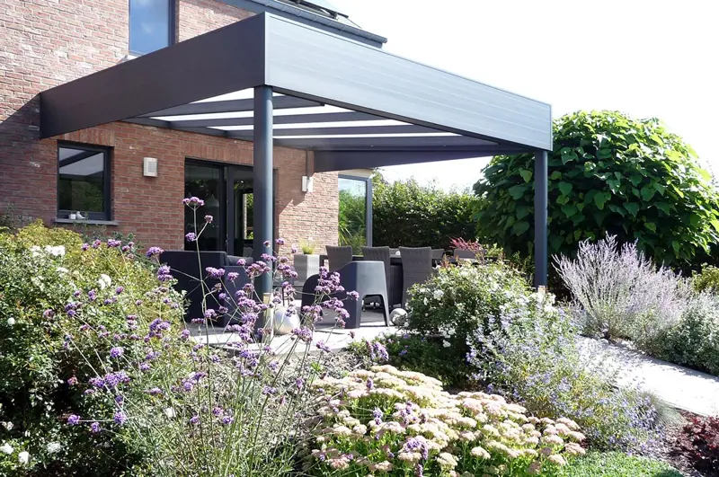 Pergola aluminium noire dans un jardin fleuri