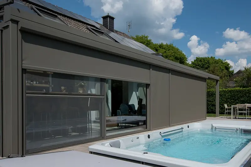 Extension vitrée à stores intégrés en bord de piscine